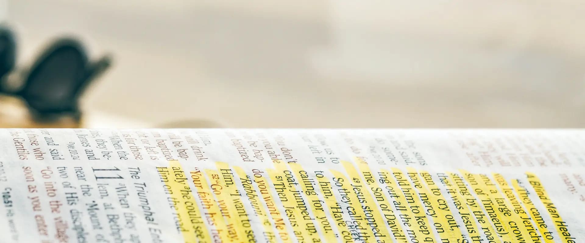 An open Bible with Mark 10 marked in yellow highlighter, where blind Bartimaeus calls out to Jesus and is told his faith has healed him